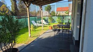a patio with a table and chairs on a deck at Budatava Vendégház in Balatonalmádi