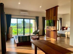 a living room with a room with a bed and a television at Zenery Lake Resort in Ban Don Klang +89 photos