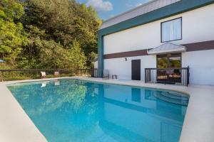 a swimming pool in front of a house at Clarion Pointe Cherokee in Cherokee