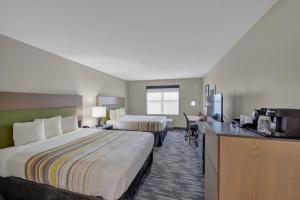 a hotel room with two beds and a desk at Country Inn & Suites by Radisson, Braselton, GA in Braselton