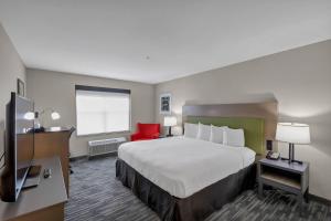 a hotel room with a large bed and a red chair at Country Inn & Suites by Radisson, Braselton, GA in Braselton +27 photos