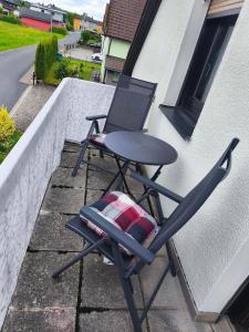a chair sitting on a balcony with a laptop on it at FeWo Rina in Pottenstein
