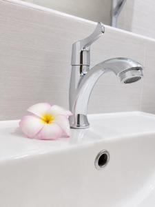 a bathroom sink with a pink flower on it at Chaba CBP Chiang Mai in Chiang Mai +23 photos