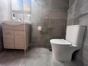 a bathroom with a toilet and a sink at Korina's Apartments in Ipsos