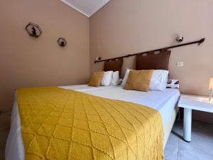 a bedroom with two beds with a yellow comforter at Korina's Apartments in Ipsos