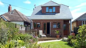 a brick house with a porch and a lawn at The Gem in Winchelsea