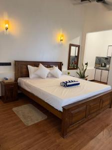 a bedroom with a large bed with a towel on it at Earthora Escape in Dickwella