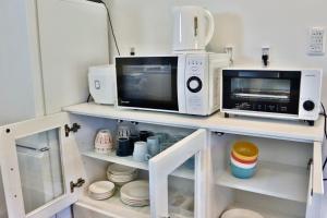 a microwave and a toaster oven on a shelf at Retreat Furano A in Furano