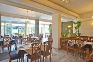 a restaurant with tables and chairs and a chandelier at Hotel Klein - Seebodenerhof in Seeboden