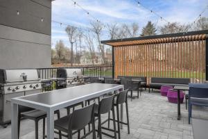 a patio with tables and chairs and a grill at Home2 Suites by Hilton Chelmsford Lowell in Chelmsford