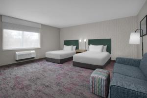 a hotel room with two beds and a couch at Home2 Suites by Hilton Chelmsford Lowell in Chelmsford +31 photos