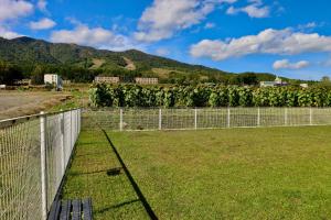 a fence in front of a field of plants at Retreat Furano A in Furano