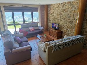 a living room with couches and a stone wall at Los Cerezos in Rada
