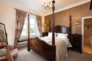 ein Schlafzimmer mit Himmelbett und Fenster in der Unterkunft Altskeith Country House in Aberfoyle
