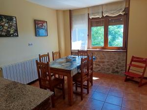 a dining room with a wooden table and chairs at Los Cerezos in Rada