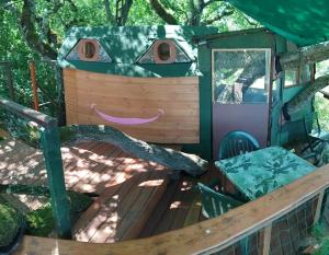 a outside view of a tree house with a bench at B&B La Cabane Insolite in Monès