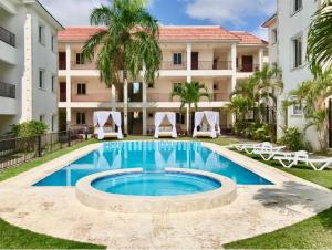 a swimming pool in front of a building at Seven beaches Palmeral in Punta Cana
