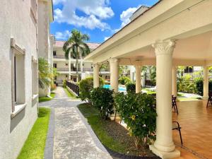 a courtyard of a building with columns and plants at Seven beaches Palmeral in Punta Cana