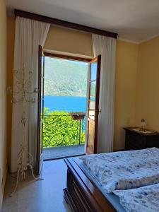 a bedroom with a large window with a view of the ocean at Casa Farfalla in Cannobio