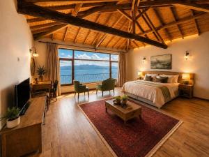 ein großes Schlafzimmer mit einem Bett und einem großen Fenster in der Unterkunft Lithos Assos in Ayvacık
