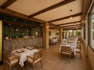 ein Restaurant mit Tischen und Stühlen und einer Bar in der Unterkunft Lithos Assos in Ayvacık