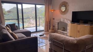 a living room with a couch and a fireplace at Mavinin ve Yeşilin dansı, Panoramik manzara, 75m2 in Marmaris