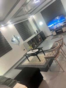 a living room with a table and chairs and a tv at Heart of Pasig in Manila