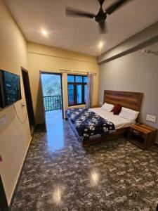 a bedroom with a bed and a large window at Sai Homestay in Mussoorie +2 photos