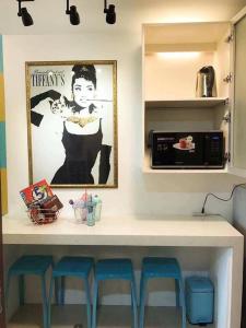kuchnia z blatem ze stołkami i kuchenką mikrofalową w obiekcie Tiffany Room At Shell Residences w mieście Manila