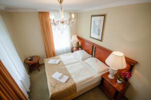 a hotel room with a bed and a chandelier at Hotel Villa Huber in Afritz