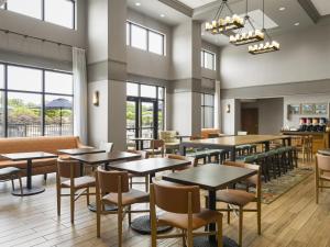 a dining room with tables and chairs and windows at Hampton Inn & Suites Braselton in Braselton