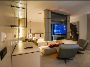 a living room with a couch and a bed and a television at VENTO MARE Çeşme in Çeşme