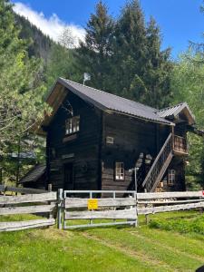 a log cabin with a fence in front of it at HeinrichH in Teuchl