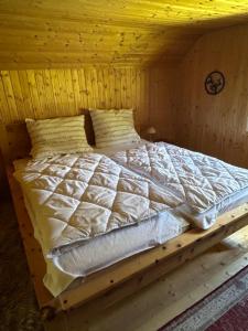a bed in a wooden room with a wooden ceiling at HeinrichH in Teuchl