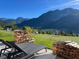a picnic table and a pile of logs and a mountain at Alpencabin Montafon in Vandans