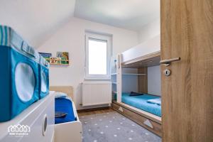 a small room with two bunk beds and a window at BORG VendégHázak - Tiszakécske in Tiszakécske