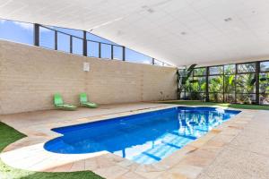 an empty swimming pool in a house with windows at Quality Hotel Point Cook in Point Cook