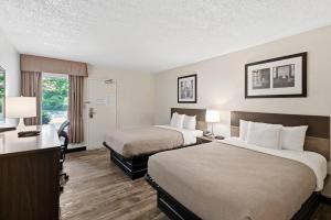 a hotel room with two beds and a desk with lamps at Quality Inn Duluth - Atlanta Northeast in Duluth +33 photos