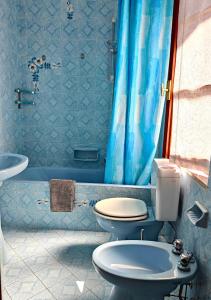 a bathroom with two toilets and a blue shower curtain at Casa Farfalla in Cannobio +31 photos