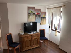 a living room with a tv and two chairs at B&B Rot in Bohinjska Bela