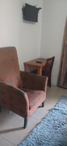 a living room with a chair and a table at AS contractors accommodation in Bronkhorstspruit