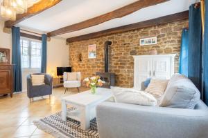 a living room with a couch and a brick wall at Gîte Ty Traon piscine partagée in Ergué-Gabéric