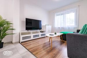 a living room with a tv and a couch and a table at BORG VendégHázak - Tiszakécske in Tiszakécske