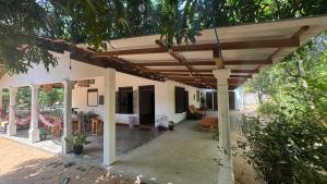 a porch of a house with a wooden pergola at Waves & Paws Hostel in Arugam Bay +13 photos