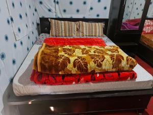 a bed with a red and yellow blanket on it at grand holiday camp in Sari