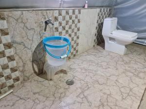 a bathroom with a toilet and a bucket in it at grand holiday camp in Sari
