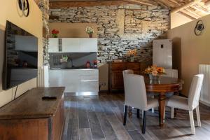 a kitchen and dining room with a wooden table and chairs at Little Chariot in Monastero di Lanzo
