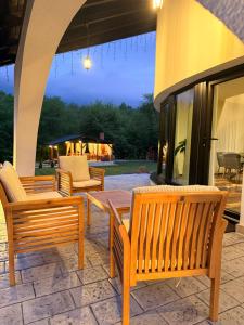 a group of wooden benches sitting on a patio at Julien House in Prisaca Dornei