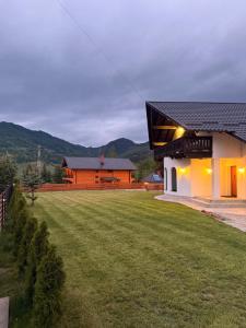 a house with a large yard next to a building at Julien House in Prisaca Dornei