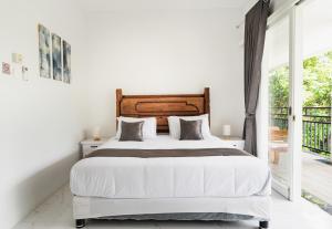 a white bedroom with a large bed and a balcony at THE SANDS LOMBOK in Mangsit +38 photos
